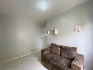 Interior de uma sala com sofá e piso de cerâmica.