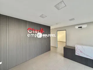 Uma sala de estar com parede de painéis verticais cinzas e piso de cerâmica clara.