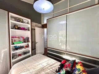 Quarto com armários e cabeceira visível na sala.