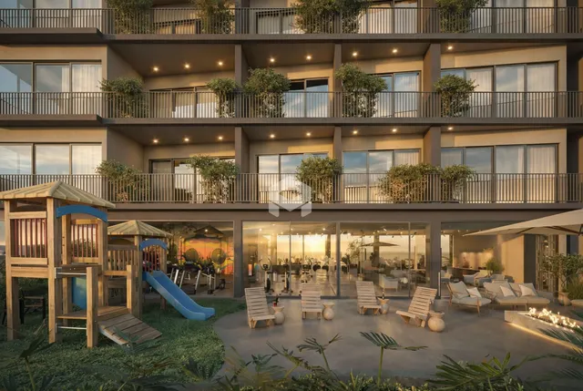 Vista da fachada de um edifício residencial moderno com terraço e área externa.