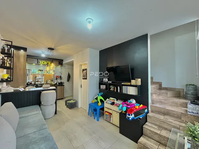 Sala de estar com cozinha integrada e acesso à escada