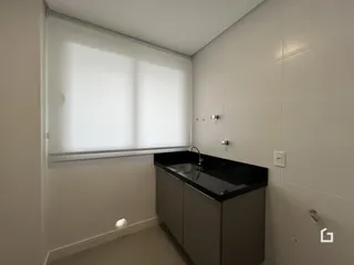 Foto de um banheiro interno com bancada escura e revestimento de parede.