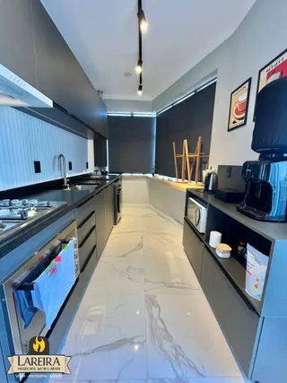 Foto de uma cozinha moderna com armários escuros e piso de mármore claro.