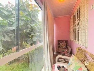 Quarto com grande janela de vidro e vista para o jardim.