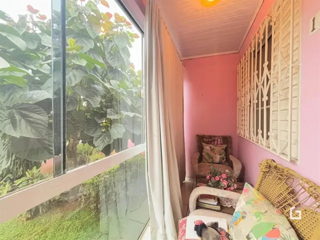 Quarto com grande janela de vidro e vista para o jardim.