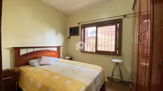 Quarto com cama de madeira e janela no ambiente.