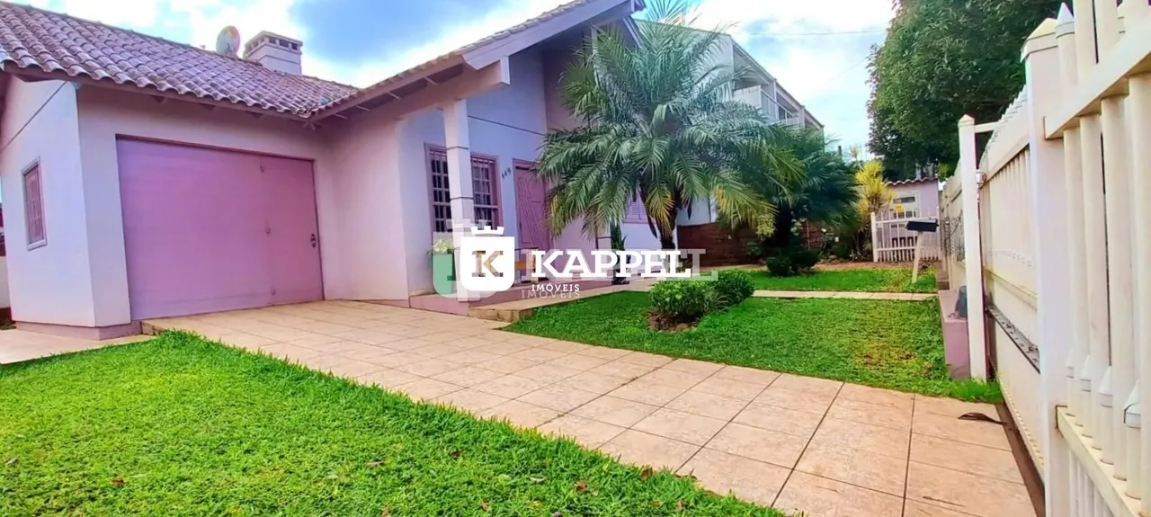 Fachada de uma casa com garagem e jardim em Lajeado.