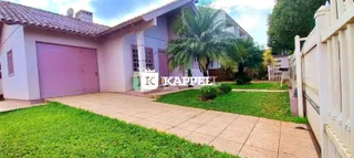 Fachada de uma casa com garagem e jardim em Lajeado.