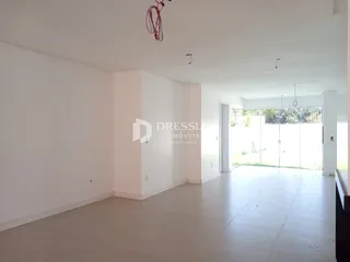 Espaço interno amplo com paredes brancas e piso claro.