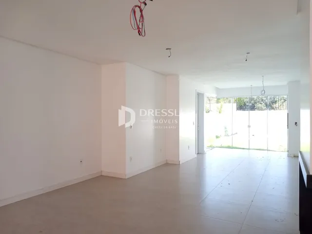 Espaço interno amplo com paredes brancas e piso claro.