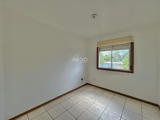 Ambiente interno com paredes brancas e piso de cerâmica.