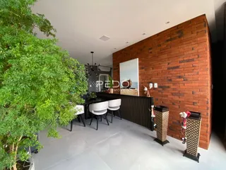 Sala de estar com parede de tijolos aparentes e piso claro.