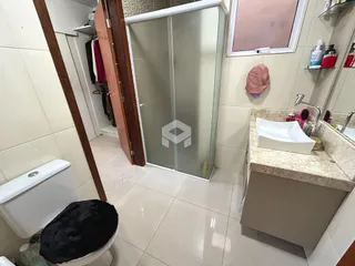 Foto de um banheiro com piso de cerâmica e box de vidro.