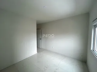 Hall de entrada com piso de porcelanato claro e paredes brancas.