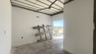 Interior de um cômodo com paredes brancas e teto exposto.