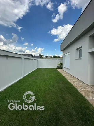 Fachada de uma casa branca com gramado verde.