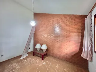 Ambiente interno com parede de tijolos aparentes e piso de carpete claro.