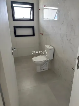 Um corredor com paredes brancas e piso de cerâmica.
