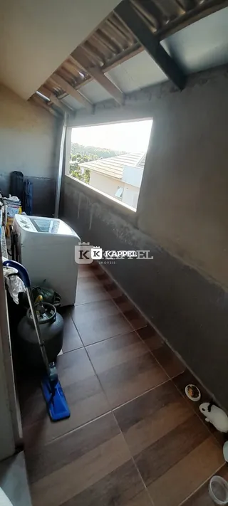 Foto de um corredor com piso de cerâmica e janela.