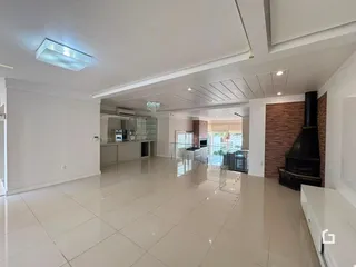 Ambiente interno de uma sala ampla com piso de cerâmica clara.