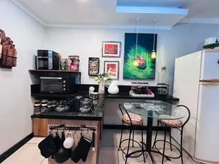 Cozinha moderna com bancadas escuras e eletrodomésticos pretos.