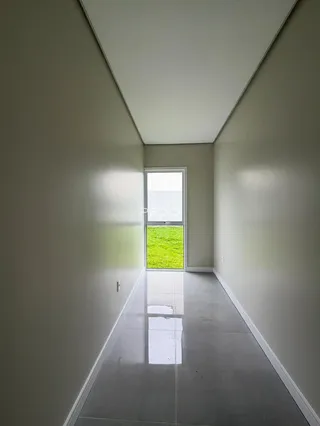 Corredor interno com janela que dá para o jardim.