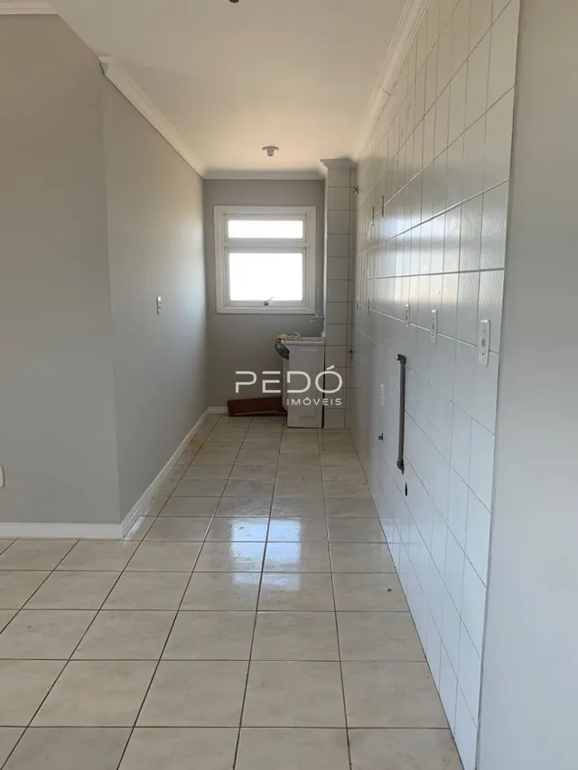 Corredor interno com piso de cerâmica claro.