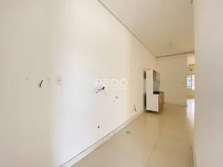 Vista de um corredor interno de uma residência com paredes brancas e piso claro.