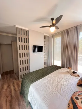 Quarto com cama e piso de madeira no interior da propriedade.