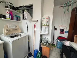Foto de uma área de serviço com máquina de lavar e prateleiras em um imóvel.