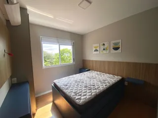Quarto com cama de casal e janela com vista para a vegetação.