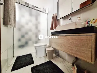 Um banheiro com piso de cerâmica e box de vidro é mostrado na propriedade.