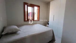Foto de um quarto com cama e janela de madeira em um imóvel.