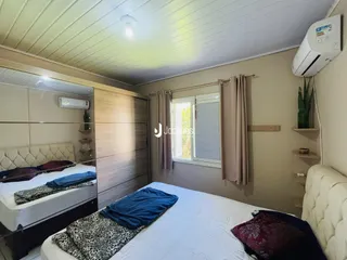 Quarto com duas camas de solteiro e guarda-roupa em um imóvel no Brasil.