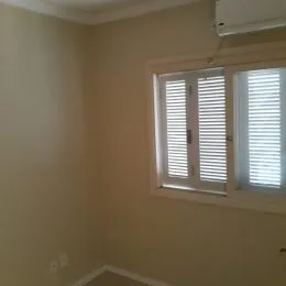 Parede interna com janela e aparelho de ar-condicionado em um imóvel.