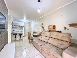 Sala de estar com sofá e mesa de jantar em apartamento no Brasil.