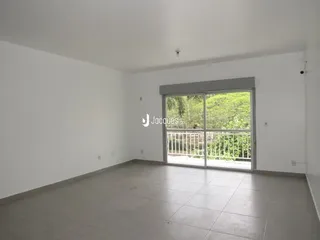 Sala de estar ampla com piso de concreto e porta de vidro voltada para o exterior.