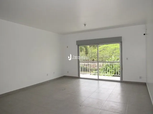 Sala de estar ampla com piso de concreto e porta de vidro voltada para o exterior.