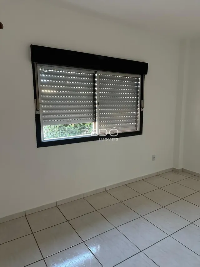Parede interna com janela coberta por venezianas em um imóvel.