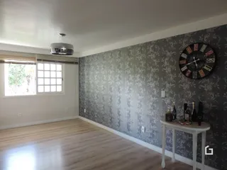 Ambiente interno com piso de madeira e parede com papel de parede na Lajeado.