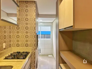 Imagem de uma cozinha com revestimento de parede e armários em um apartamento.