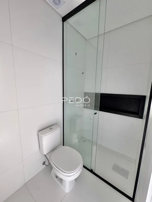 Foto de um banheiro com azulejos brancos e vaso sanitário.