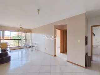 Sala de estar com piso de cerâmica clara e grandes janelas.