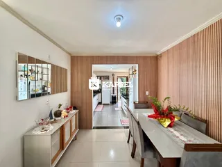 Esta é uma foto de uma sala de estar e jantar com painéis de madeira e mesa de jantar.