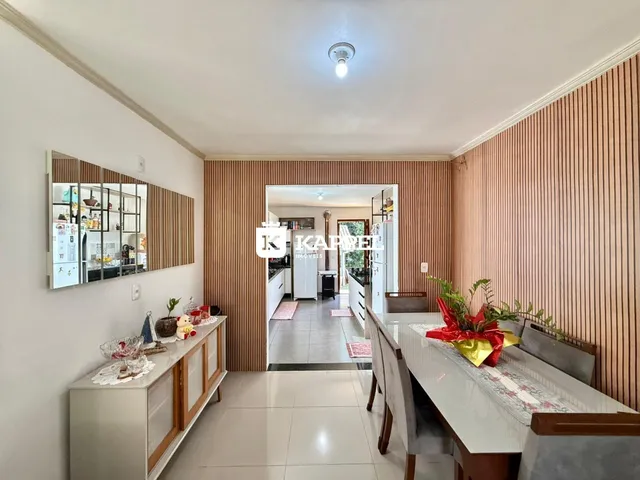 Esta é uma foto de uma sala de estar e jantar com painéis de madeira e mesa de jantar.