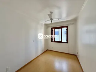 Foto de um corredor interno com piso de madeira clara e uma janela.