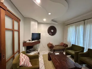 Sala de estar com lareira e móveis de madeira em um imóvel no Brasil.