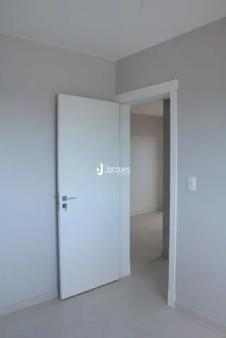 Vista de um corredor interno com porta branca.