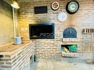 Parede de tijolos expostos com uma lareira decorativa em um ambiente interno.