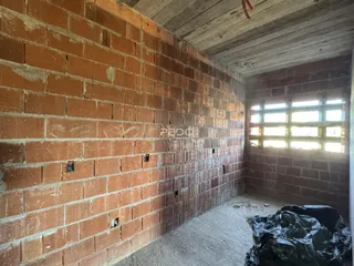 Parede de tijolos aparentes em uma área interna de construção.